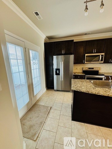 A kitchen with a refrigerator, sink, and microwave.