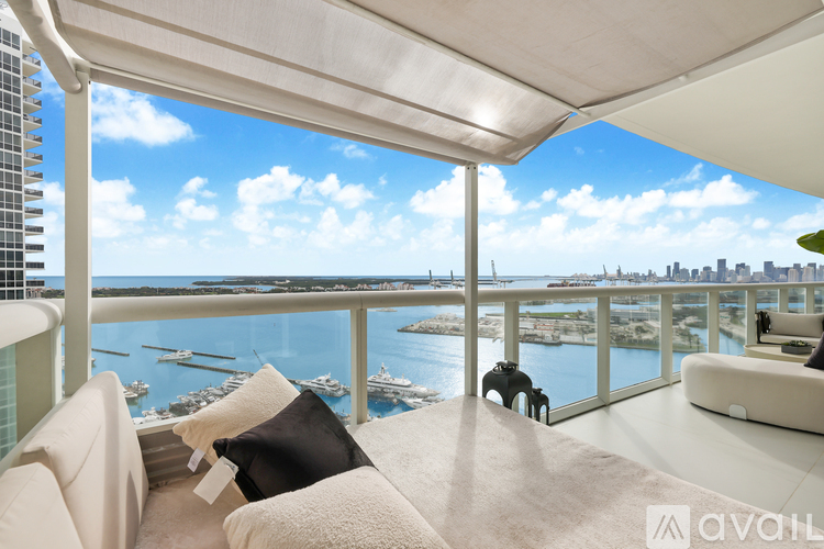A living room with a view of the water and city skyline.