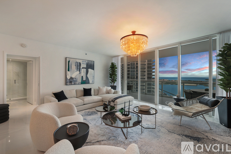 A modern living room with a large window overlooking the sea.