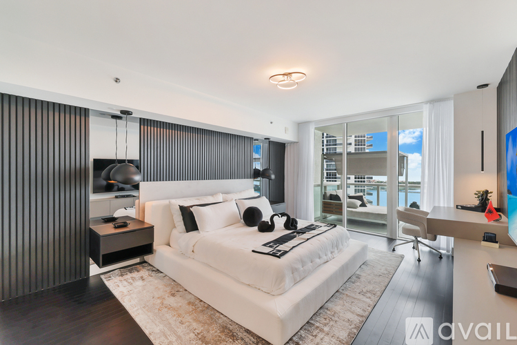 A modern bedroom with a large bed and a television.