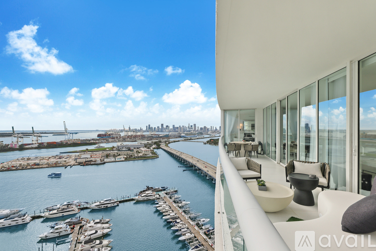 A modern building with a view of a marina and a city skyline.