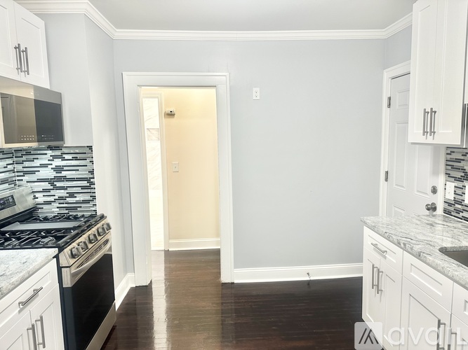 A kitchen with white cabinets and a black stove top oven.