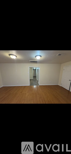 A room with wooden flooring and a white door.
