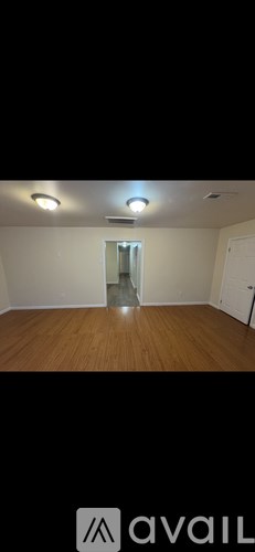 A room with wooden flooring and a white door.
