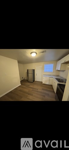 A kitchen area with a refrigerator, sink, and cabinets.