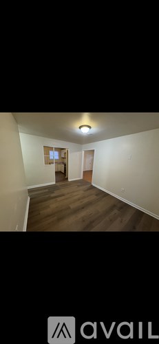 A room with wooden flooring and white walls.