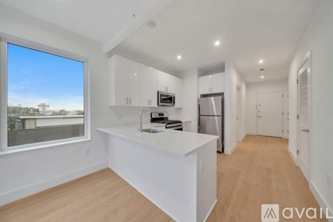 A modern kitchen with white cabinets and a large island.