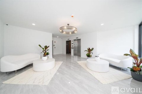 A modern living room with white furniture and a marble floor.