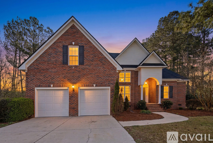A house with a brick facade and two garage doors is available for purchase.