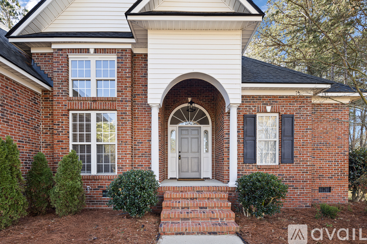 A house with a white door and windows with black shutters.