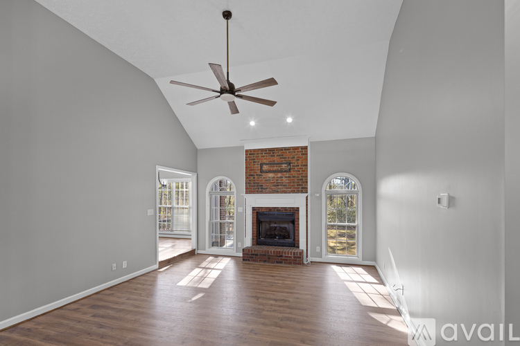 A spacious room with a fireplace and a ceiling fan.