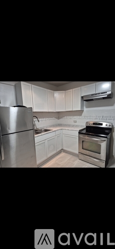 A modern kitchen with stainless steel appliances and white cabinets.