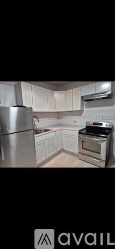 A modern kitchen with stainless steel appliances and white cabinets.
