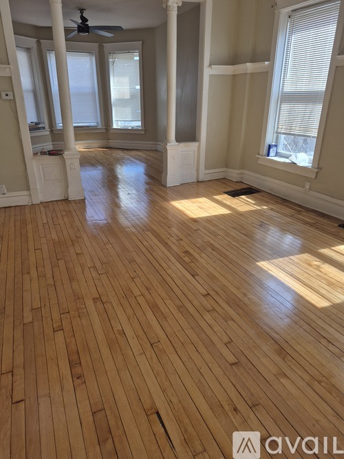 A room with wooden flooring and a ceiling fan.