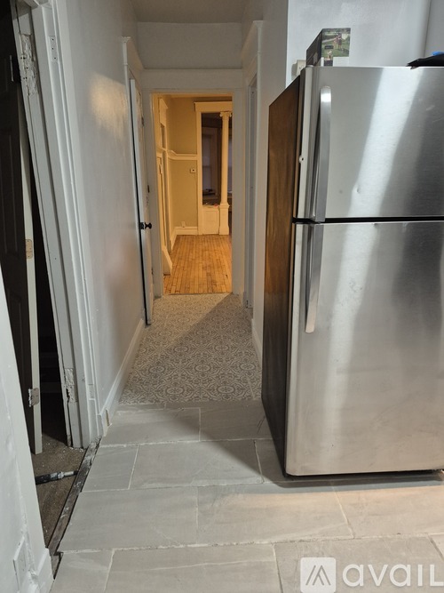 A long hallway with a refrigerator on the right.