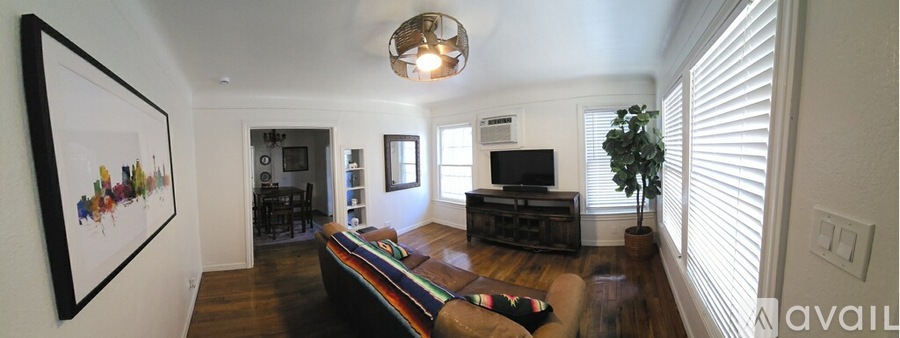 A living room with a couch and a painting on the wall.