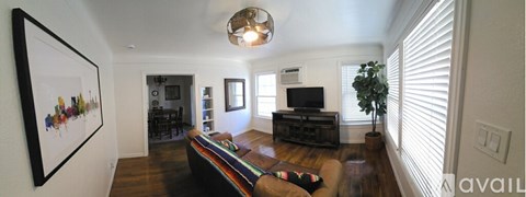 A living room with a couch and a painting on the wall.