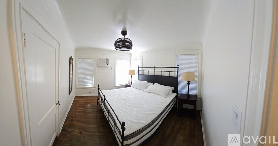 A bedroom with a bed, nightstand, and lamp.