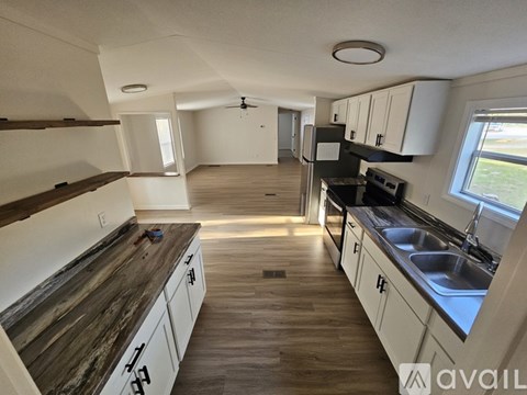 A kitchen with wooden countertops and white cabinets.