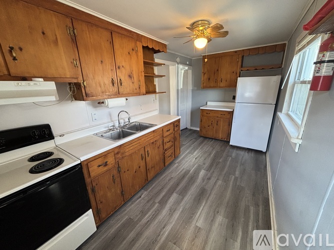 A kitchen with wooden cabinets and a black stove top oven.