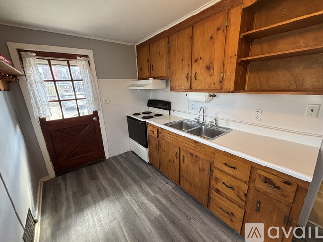 A kitchen with wooden cabinets and a window.