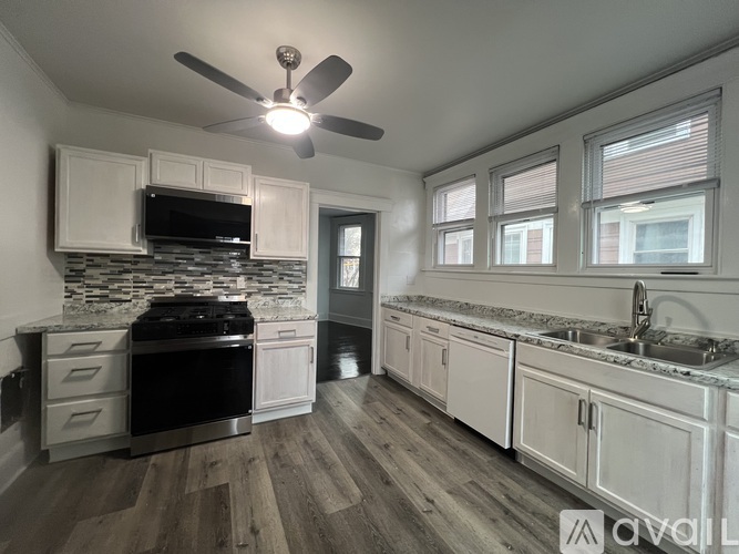 A modern kitchen with a black stove top oven and white cabinets.