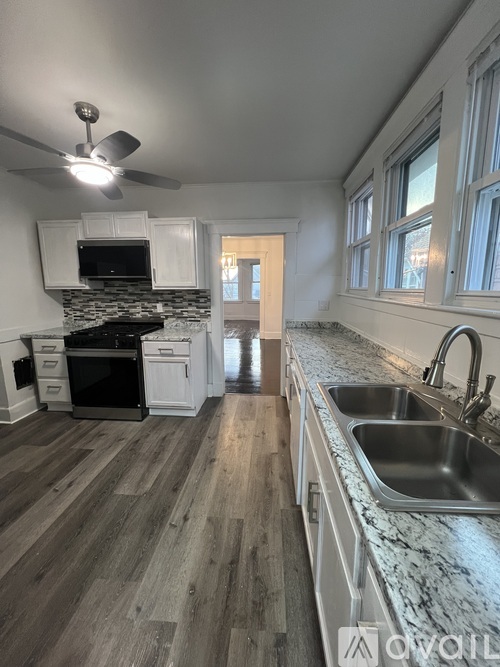 A kitchen with a marble countertop and wooden flooring.