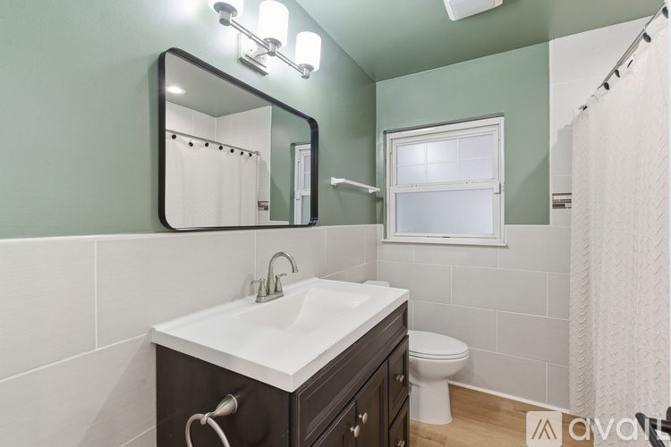 A bathroom with a white sink and a mirror above it.