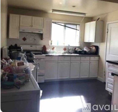 A kitchen with white cabinets and a stove top oven.