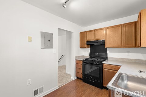 A kitchen with a stove top oven and a sink.