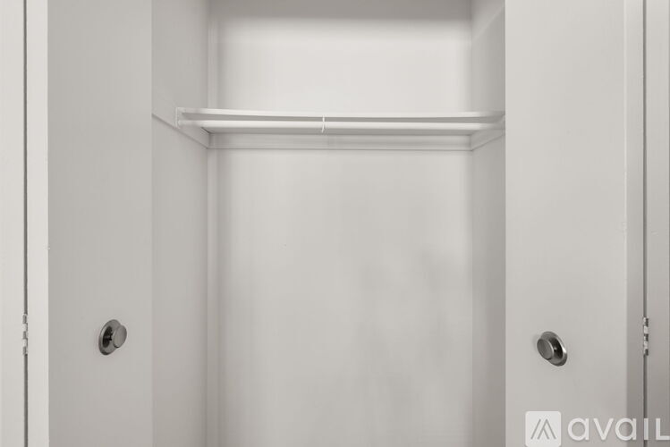 A white door with a handle and a shelf above it.