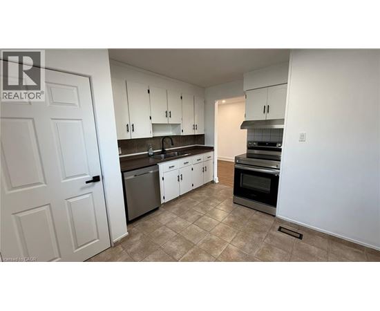 A kitchen with white cabinets and a tiled floor.