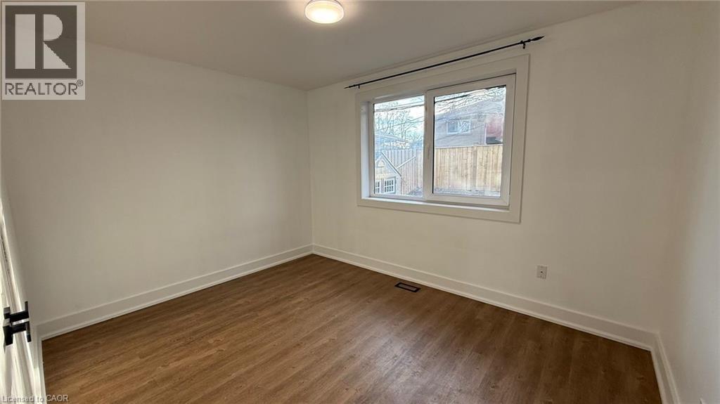 A room with a window and wooden flooring.