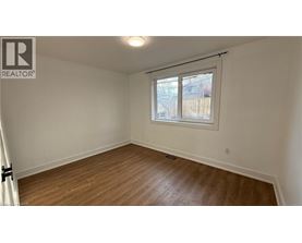 A room with a window and wooden flooring.
