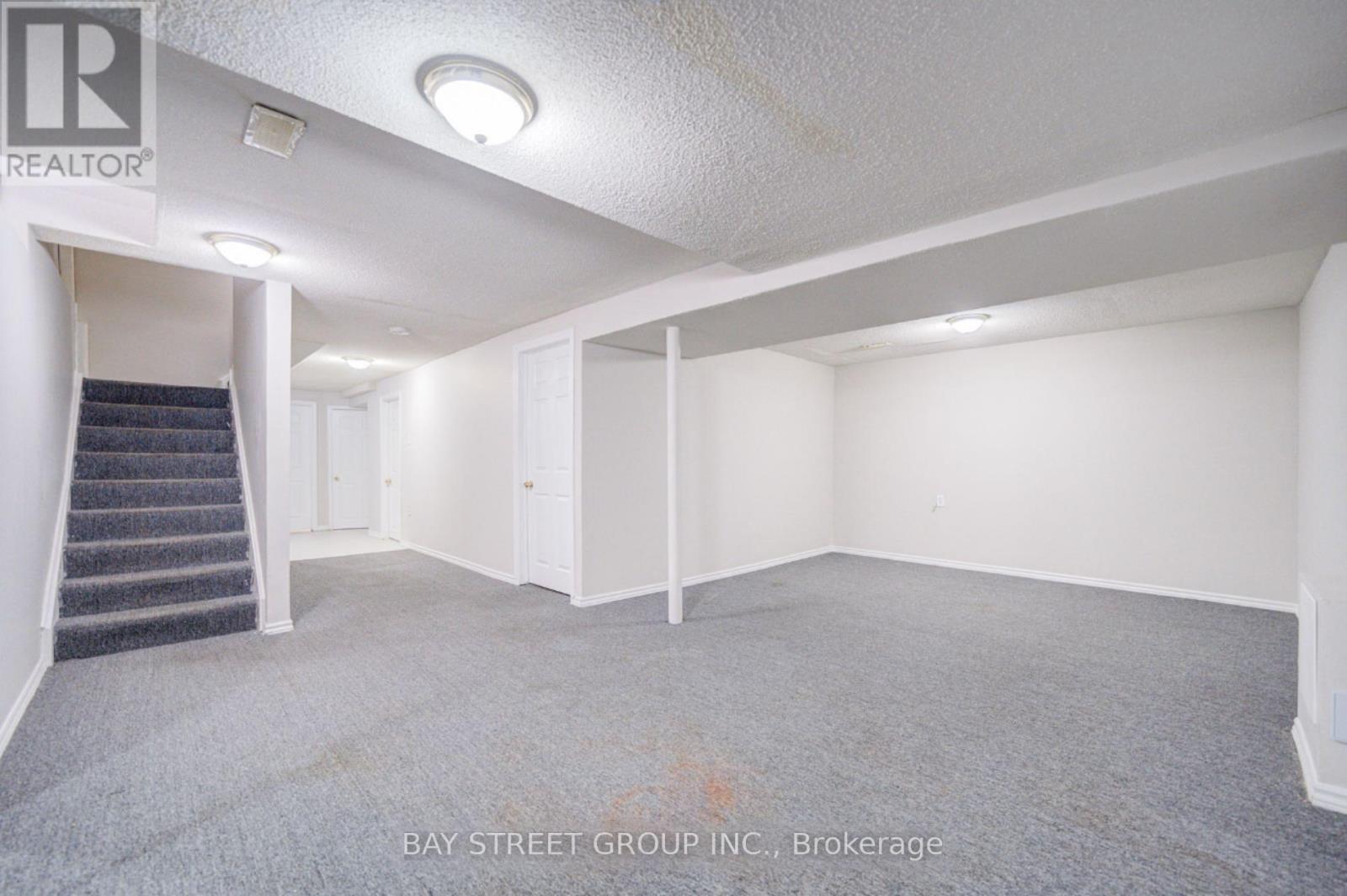 A spacious room with a staircase leading to another level.