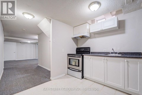 A kitchen with white cabinets and a black countertop.