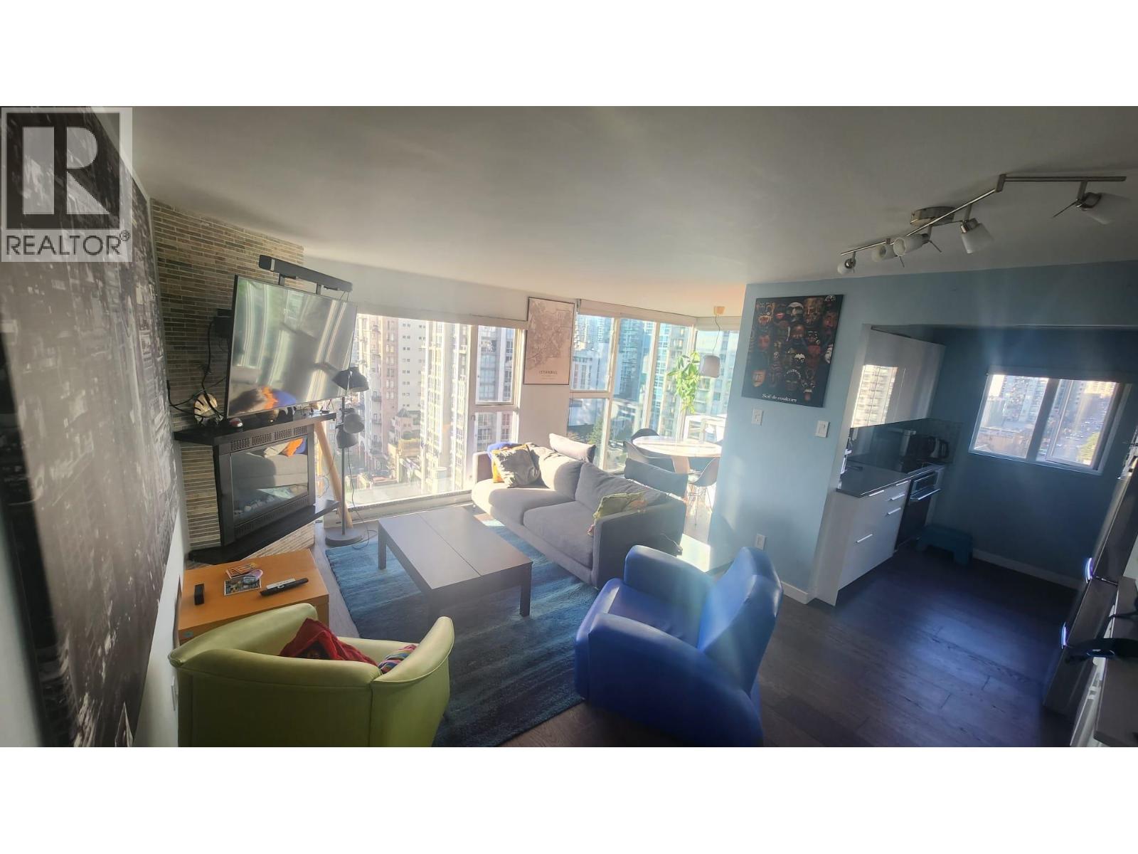 A living room with a television, two chairs, and a couch.