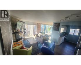 A living room with a television, two chairs, and a couch.