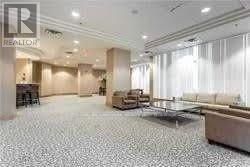 A spacious living room with a patterned floor and a large window with curtains.