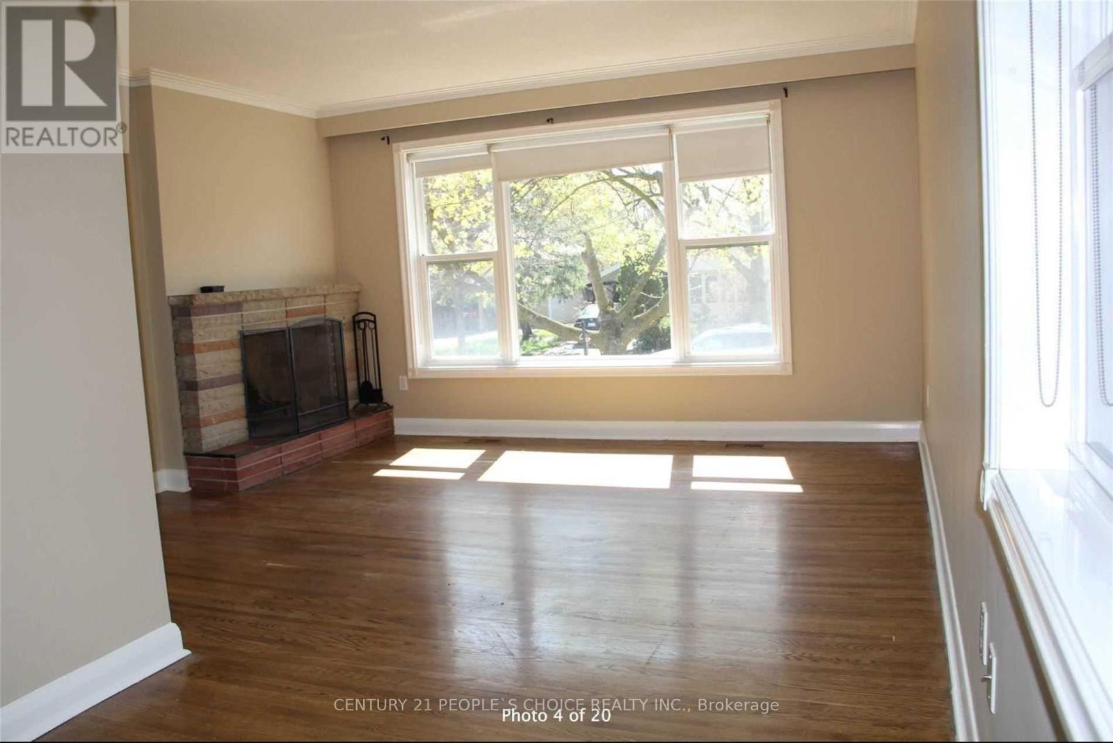 A room with a fireplace and a window letting in sunlight.