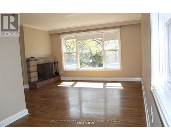 A room with a fireplace and a window letting in sunlight.