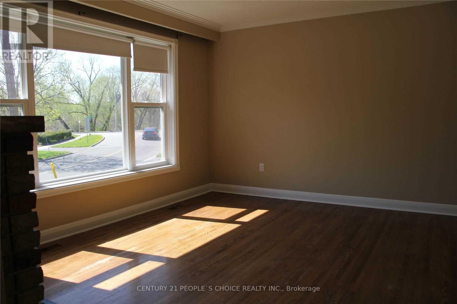 A room with a window and wooden floors.
