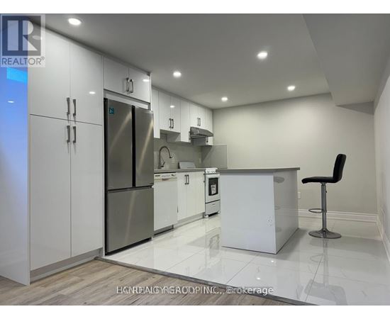 A modern kitchen with white cabinets and a stainless steel refrigerator.