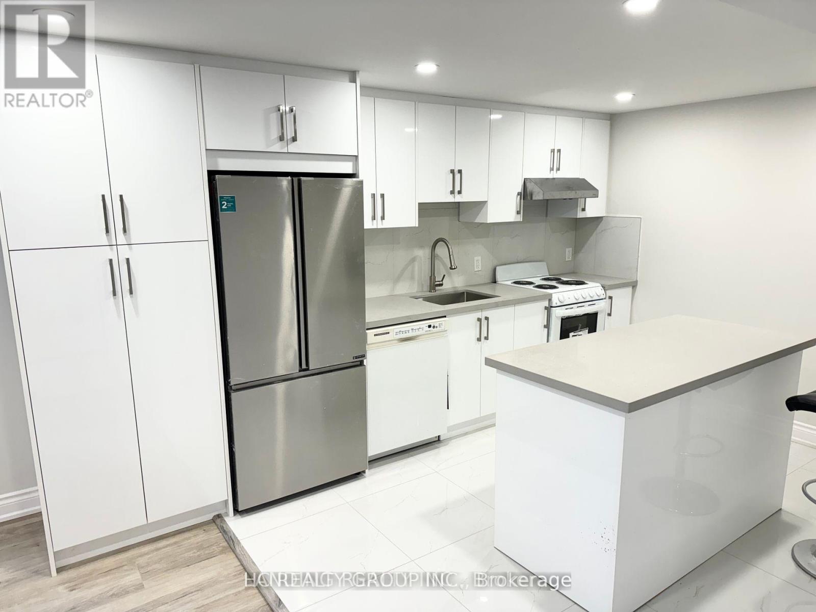 A modern kitchen with white cabinets and stainless steel appliances.