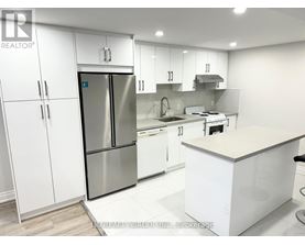 A modern kitchen with white cabinets and stainless steel appliances.