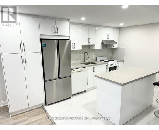 A modern kitchen with white cabinets and stainless steel appliances.