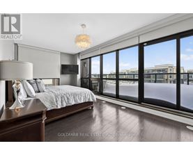 A bedroom with a large bed and a view of the outside.