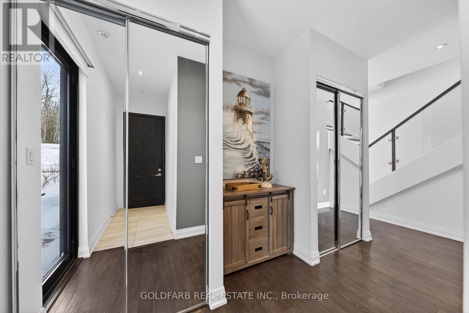 A modern interior space with a wooden floor and a staircase.
