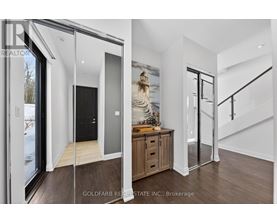 A modern interior space with a wooden floor and a staircase.