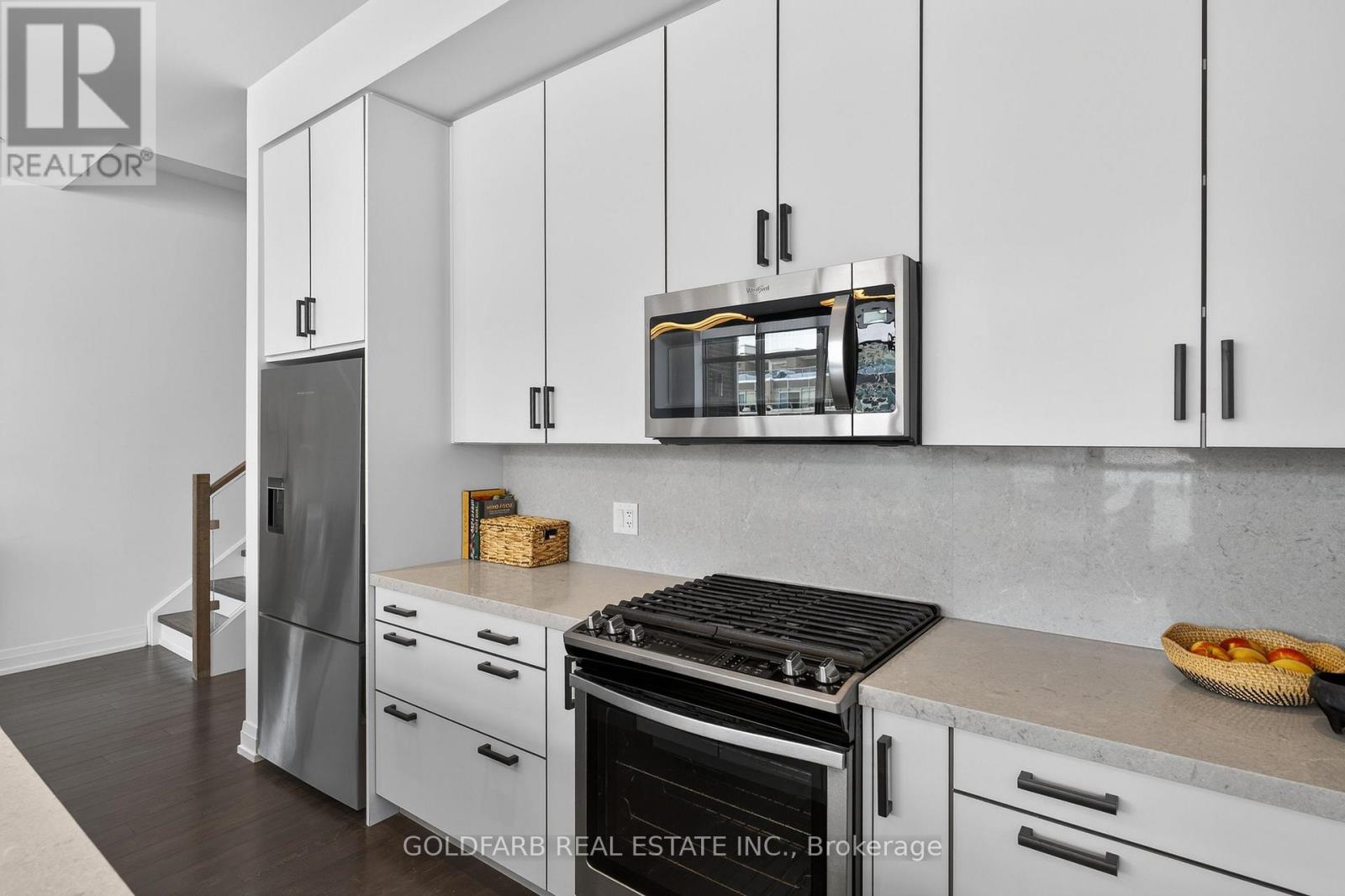 A kitchen with white cabinets and a black stove top.
